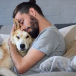 hipster man snuggling and hugging his dog, close friendship lovi